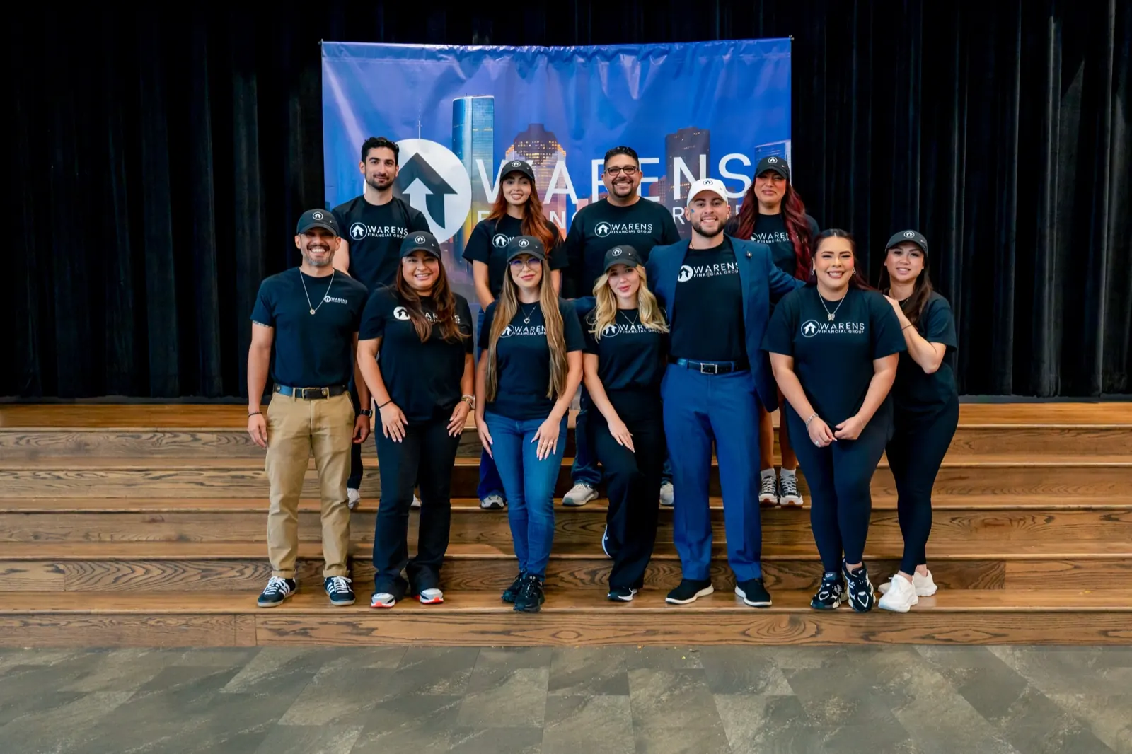 The Warens Financial Group team on stage in front of the Warens backdrop